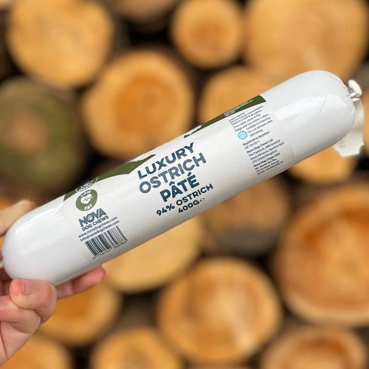 Saucisson d’autruche pour chien présenté sur un bois vieilli