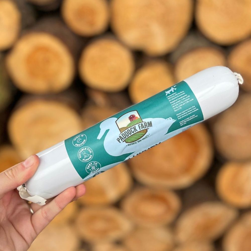 Friandise naturelle au canard posée sur une planche en bois rustique