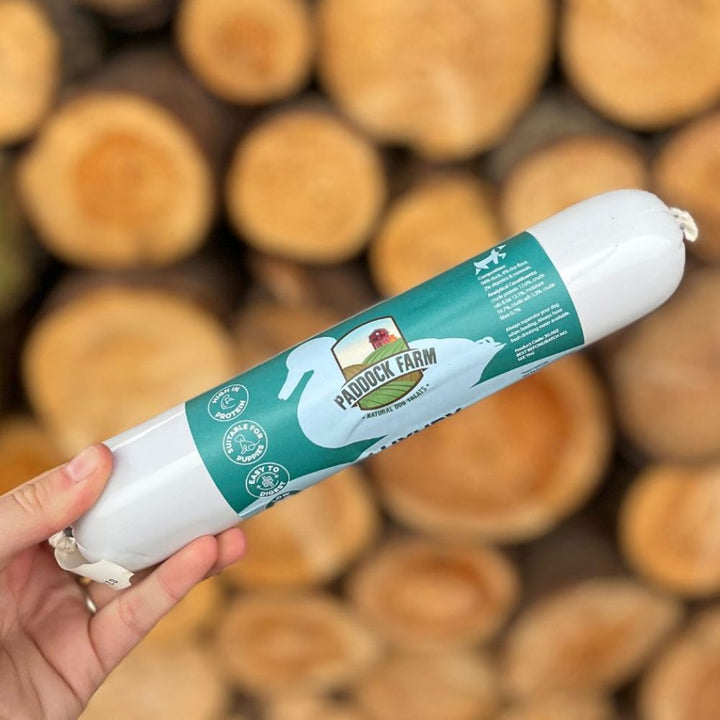 Friandise naturelle au canard posée sur une planche en bois rustique
