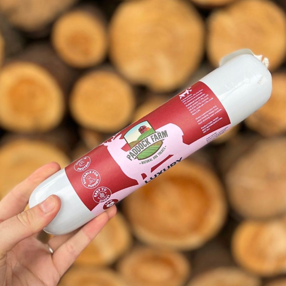 Saucisson gibier pour chien présenté sur un fond bois brut et texturé

