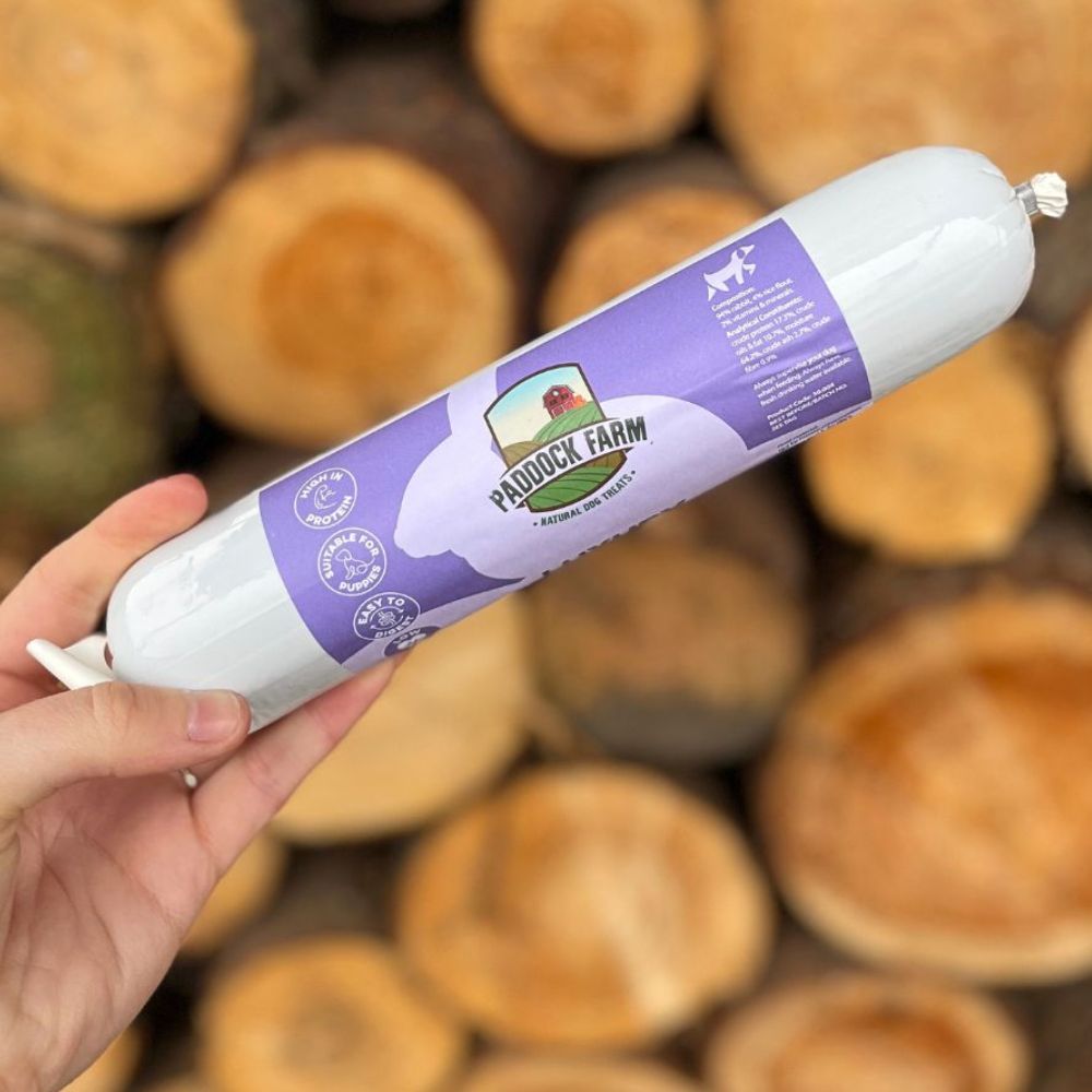Bâton de viande de lapin pour chien présenté sur fond bois brut